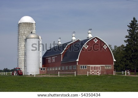 red barn with silos and tractor on a dairy farm