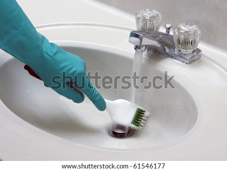 sink cleaned with a gloved hand and brush