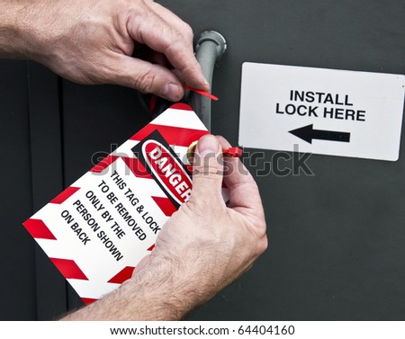 electrician places a lockout tag on a power panel
