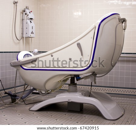 handicapped fiberglass bathtub with a door access in a tiled bathroom