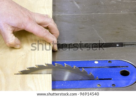 table saw blade  cutting a piece of oak board