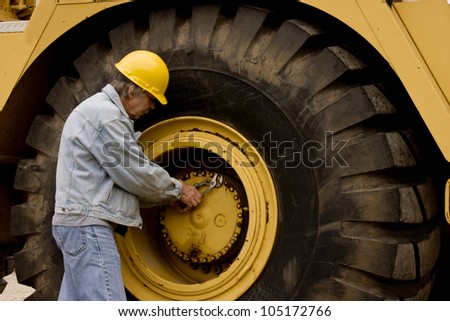 mechanic repairing huge truck tire on heavy equipment