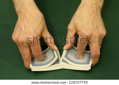 card dealer shuffles cards over a green felt background