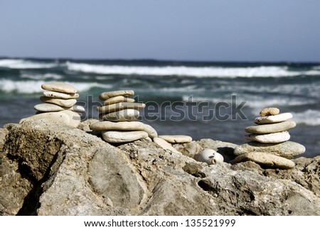 zen stones stacked on coral by the shore of the sea