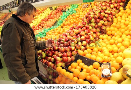 man is grocery shopping in the produce section of an American Super Market