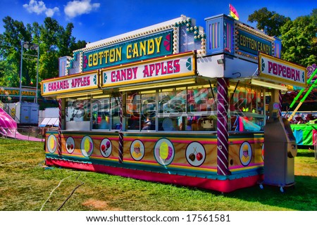 View of concession stand of cotton candy and caramel apples at a carnival.