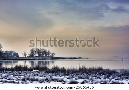 View of calm sea on a winter morning after a snowfall.