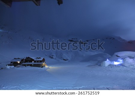 Night Sky With Old Wood Cabin and Ice Hotel in winter scene