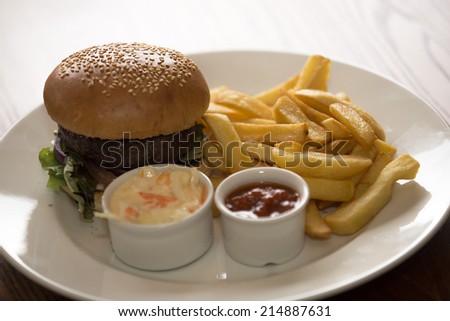 A shot of a Delicious Burger and chips