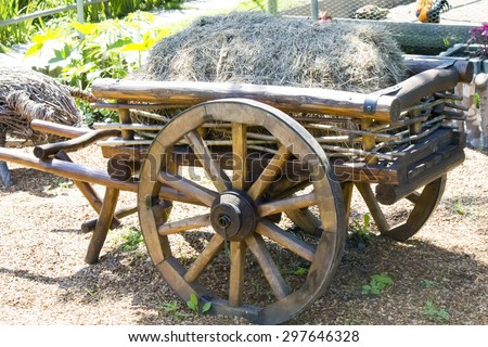 The old cart with hay stands in anticipation of the horse