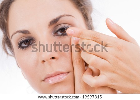 Young woman putting a contact lens