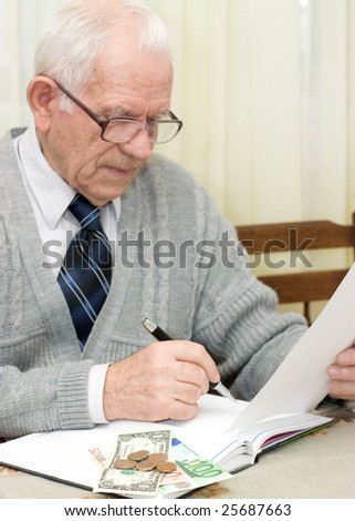 Elderly man sitting on the table and making a financial plan