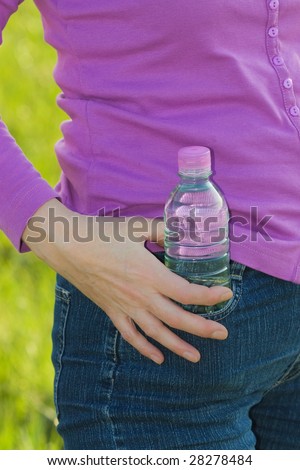 Little bottle with water in the jeans pocket