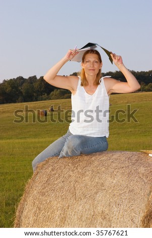 Mature Woman holding a clipboard above her head at sunset