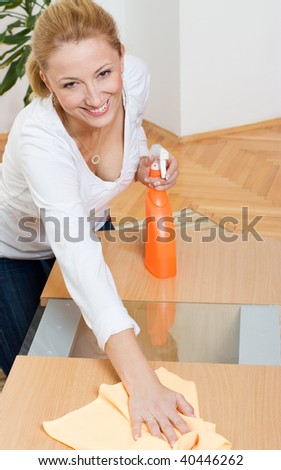 stock photo Young blonde housewife cleaning a table