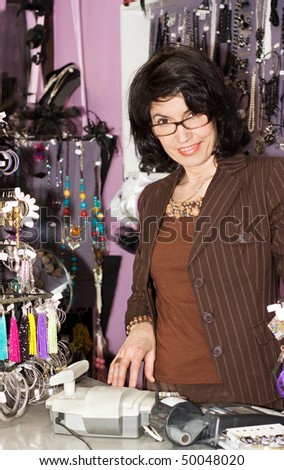 Attractive Female sales clerk behind the cash register