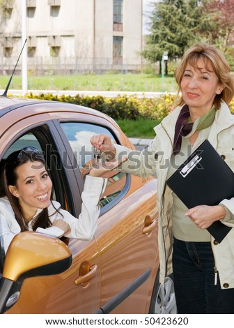 Young woman getting a car keys from a Car Salesperson