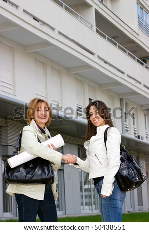 Real Estate woman Agent  standing  with young woman customer in front  of a new building and Handshaking