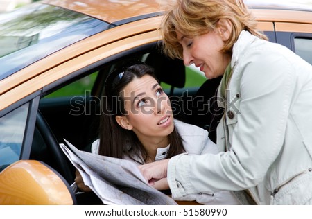Young  female driver asking   female passerby  about direction