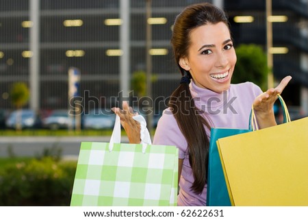 Lovely teenage girl with shopping bags standing in front a shopping mall.