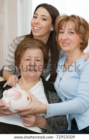 Grandmother Mother Daughter. Family with piggy bank at home.