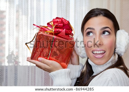 Happiness Teenage Girl looking up  and holding a red Gift Box .