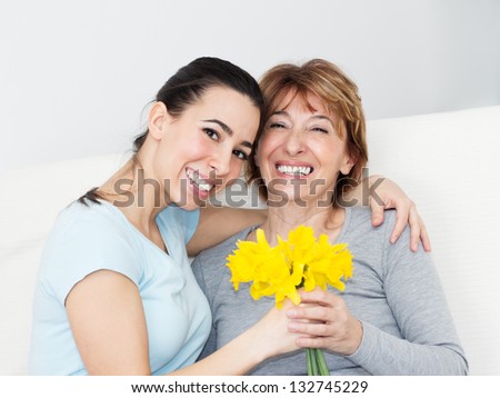 Beautiful Young Woman Giving To Her Mother Flowers For Mother\'S Day.