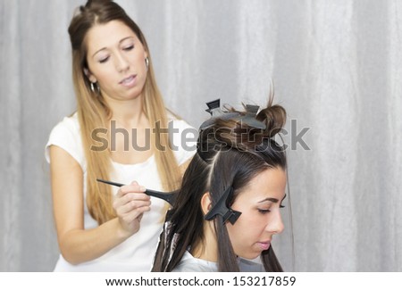 Young woman coloring hair in the hairdresser\'s salon.