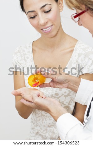 Mature female doctor giving  a young woman the medicine.