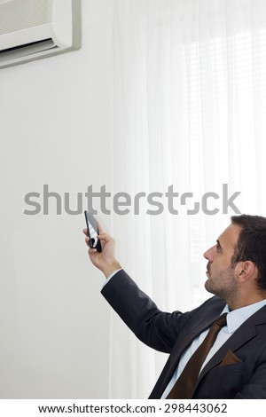 Closeup  of businessman  remote controlling office  temperature with his a smart phone.