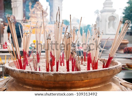 burning incense sticks in brass Incense bowl at buddhist shrine