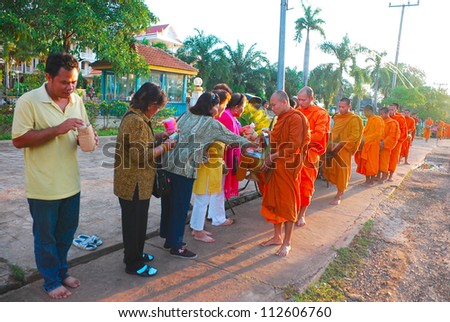 CHAMPASAK,LAOS-OCT 25:A long line of monks receiving rice offering from people at Pakse city in Champasak,Laos on October 25 2009. Offering food is the oldest and most common rituals in Buddhism