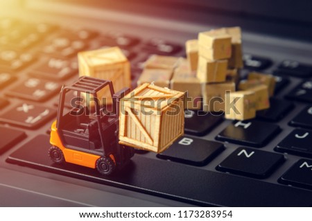 forklift freight car truck loading goods product wooden boxes and parcel on laptop computer keyboard ecommerce logistic warehouse industry concept
