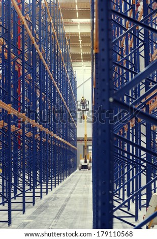 mechanic work on a hydraulic aerial work platform in a warehouse in a warehouse