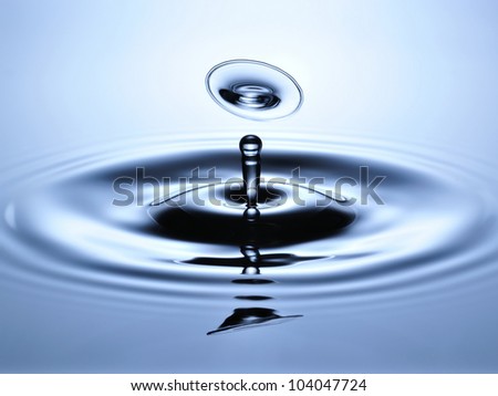 A small water drop fall on water surface and jump back to collide with the second one, forming a disk shaped splash.