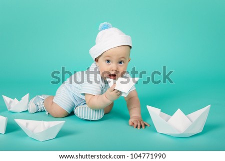 Smiling little boy plays with toy ship