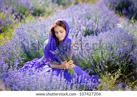 Series. Portrait of beautiful romantic woman in fairy field of lavender with bouquet