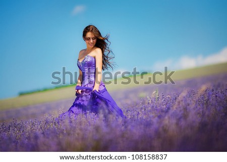 Portrait of beautiful romantic woman in fairy field of lavender