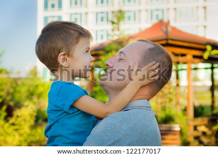 Closeup portrait of a happy father and son playing outdoors and having fun