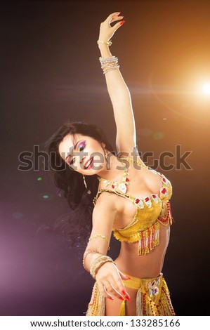 Beautiful sexy woman belly dancer. Arabian oriental professional artist in shining costume with long healthy glossy hair.