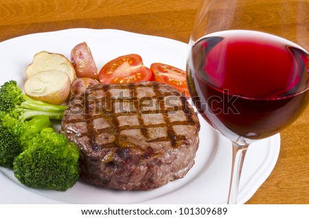 Barbecued Rib Eye Steak Served with Vegetables and a Glass of Red Wine