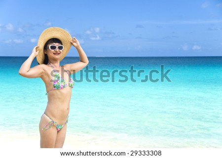 Woman in Floral String Bikini and Straw Hat on the Beach