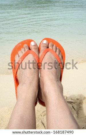 Woman Wearing Orange Flip Flop on the Beach