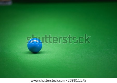 Blue ball on green snoker table.