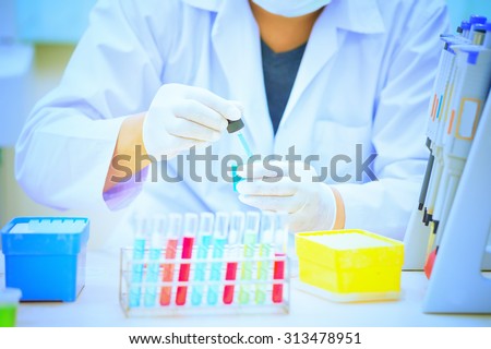 Scientist holds and examine samples in lab room
