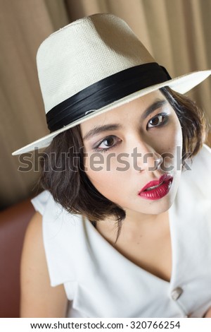 head shot of asia woman with hat in room, beauty concept