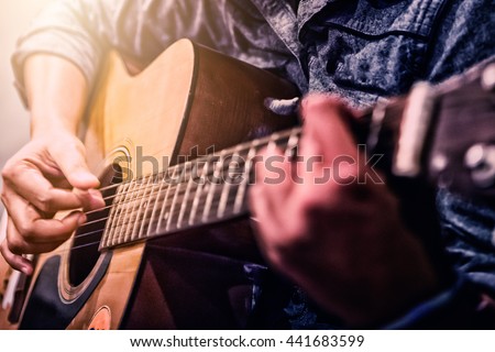 woman\'s hands playing acoustic guitar, close up