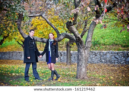 Young couple holding hands in the autumn park