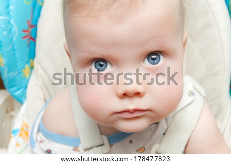Cute baby boy with big blue eyes looking up