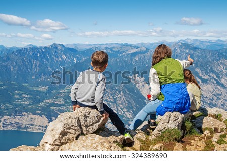 Family looking at the mountains and lake Garda on the top of Monte Baldo mountain, Alps, Italy